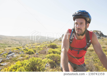 Mature man wearing tank top, bike helmet, pausing on rocky trail with hydration pack, copy space Mature man wearing tank top, bike helmet, pausing on rocky trail with hydration pack, copy space 139741359