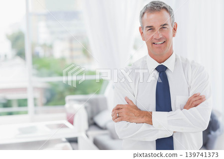 Middle-aged man standing on right in modern living room, wearing tie and wedding ring, copy space Middle-aged man standing on right in modern living room, wearing tie and wedding ring, copy space 139741373