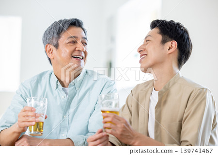 家庭:父子倆在喝啤酒 家庭:父子倆在喝啤酒 139741467