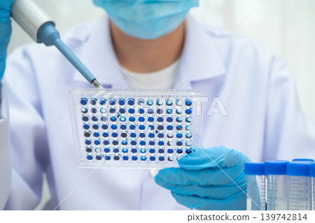 Scientist with cell culture in sample micro plate for research in science laboratory. 139742814