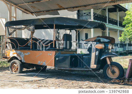 A rusty and abandoned Large multi-seat tuk tuk taxi for tourists in an abandoned hotel. The ruin and bankruptcy of the tourism business during the pandemic and crises. High quality photo A rusty and abandoned Large multi-seat tuk tuk taxi for tourists in an abandoned hotel. The ruin and bankruptcy of the tourism business during the pandemic and crises. High quality photo 139742988