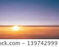 Beautiful sunset and the sun above the clouds - the view from the plane to the evening sky. Beautiful background for airlines and air travel copy space. High quality photo 139742999