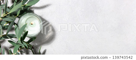 Eucalyptus Leaves and Scented Candle on Minimal Light Background Eucalyptus Leaves and Scented Candle on Minimal Light Background 139743542