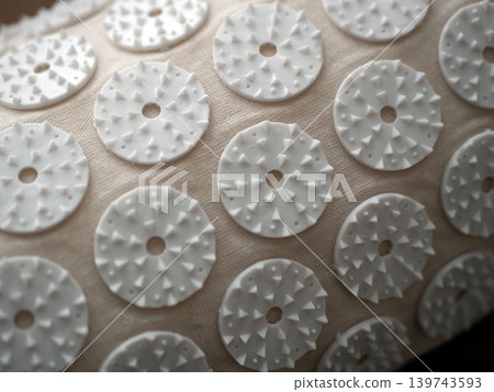 White massage applicator pads on a textured fabric surface. Home wellness tool for relaxation, acupressure, and body care 139743593