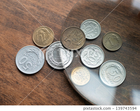 Polish coins on a wooden table. Close-up of old currency and numismatic collection Polish coins on a wooden table. Close-up of old currency and numismatic collection 139743594