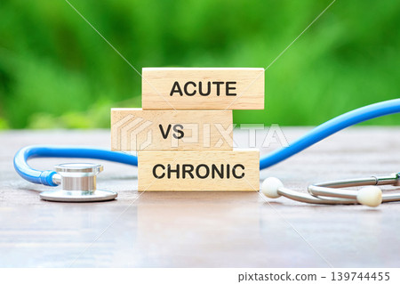 Three wooden blocks display the words Acute, VS, and Chronic, illustrating a comparison of medical conditions 139744455