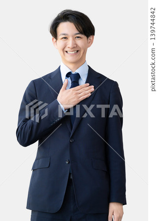 一名男性商人站著,一隻手放在胸口。 一名男性商人站著,一隻手放在胸口。 139744842