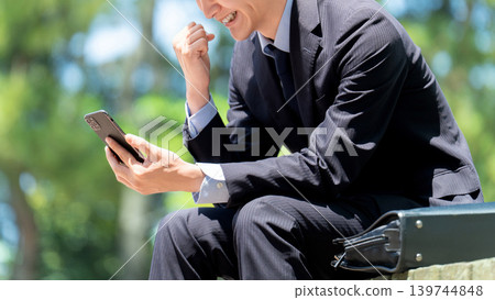 一位男商人很高興看到他的智慧型手機螢幕 一位男商人很高興看到他的智慧型手機螢幕 139744848