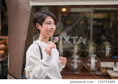 A woman eating street food in a tourist area A woman eating street food in a tourist area 139744980