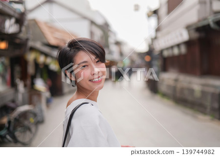 A smiling woman walking in a tourist area A smiling woman walking in a tourist area 139744982