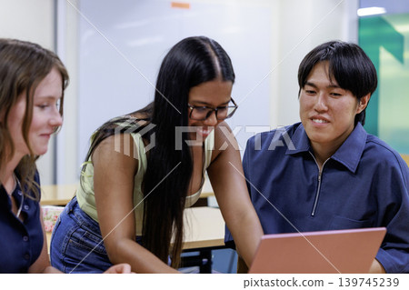 Office scene of young men and women working on laptops. Office scene of young men and women working on laptops. 139745239