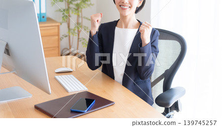 A businesswoman working on her desktop computer (making a victory pose) 139745257