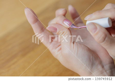 一位女士左手中指塗有凝膠指甲油。 一位女士左手中指塗有凝膠指甲油。 139745912