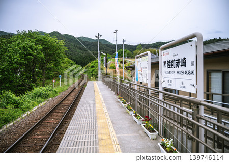 這是位於鬱鬱蔥蔥的山區中的一座無人車站的月台和車站標誌。 139746114