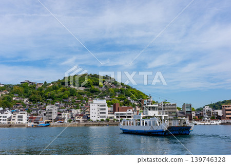 從向井島眺望渡輪和尾道市景,以及瀨戶內海的景色。 從向井島眺望渡輪和尾道市景,以及瀨戶內海的景色。 139746328