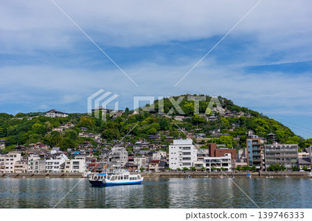從向井島眺望渡輪和尾道市景,以及瀨戶內海的景色。 從向井島眺望渡輪和尾道市景,以及瀨戶內海的景色。 139746333