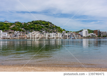 The cityscape of Onomichi and the sandy beach as seen from Mukaijima Island, a view of the Shimanami Kaido. The cityscape of Onomichi and the sandy beach as seen from Mukaijima Island, a view of the Shimanami Kaido. 139746471