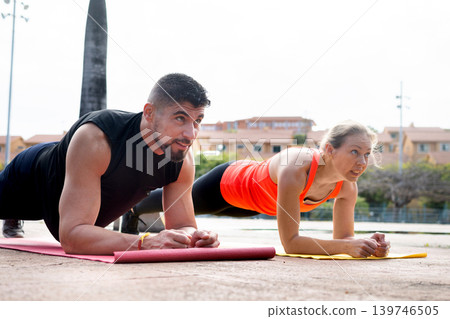 Fit Couple Doing Plank Exercise Outdoors Together Fit Couple Doing Plank Exercise Outdoors Together 139746505