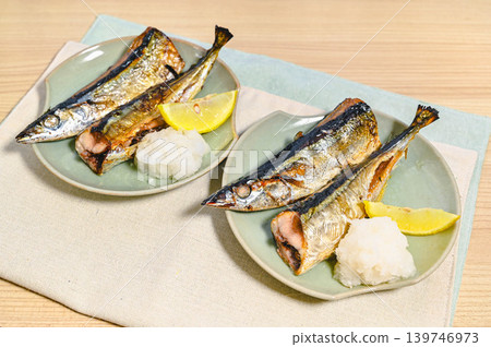 鹽烤秋刀魚配上磨碎的白蘿蔔和檸檬。 鹽烤秋刀魚配上磨碎的白蘿蔔和檸檬。 139746973
