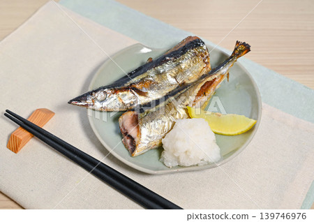 鹽烤秋刀魚配上磨碎的白蘿蔔和檸檬。 鹽烤秋刀魚配上磨碎的白蘿蔔和檸檬。 139746976
