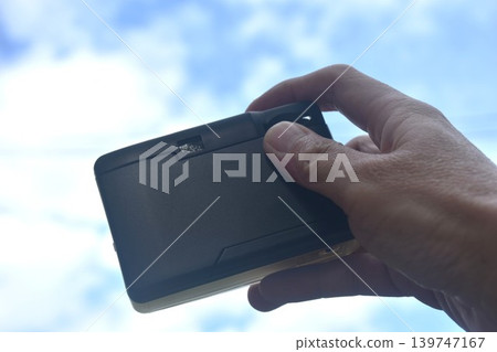 hand photo shooting with manual compact film camera of bright sky background and texture 139747167