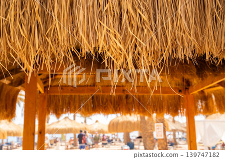 Close view of straw roof at beach resort in Sharm El Sheikh Egypt with Red Sea vacation area in soft focus. Travel and resort lifestyle Close view of straw roof at beach resort in Sharm El Sheikh Egypt with Red Sea vacation area in soft focus. Travel and resort lifestyle 139747182
