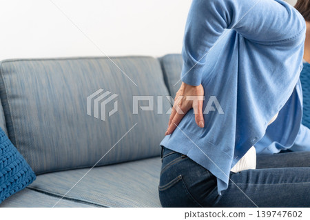 Female, lower back pain, hands Female, lower back pain, hands 139747602