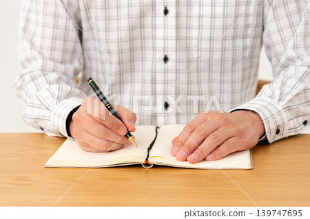 A man writing in a notebook (hands) A man writing in a notebook (hands) 139747695