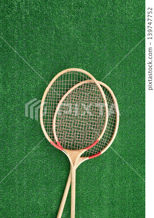 Vintage badminton rackets on green grass top view Vintage badminton rackets on green grass top view 139747752