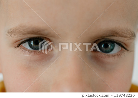 Extreme close-up portrait of a young boy focusing on blue eyes and facial details. Emotional and expressive childhood concept. 5 years Detailed child face close-up with natural lighting and soft tones 139748220