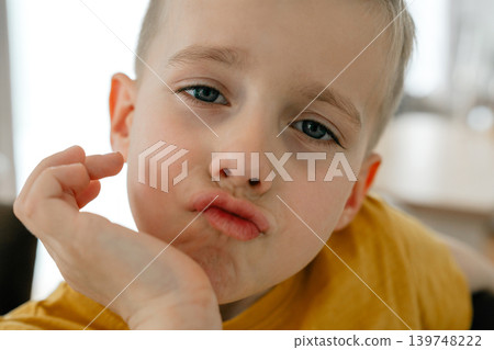 Funny portrait of little boy making playful facial expression. Casual indoor lifestyle scene with natural emotions and childhood joy. 5 years Playful boy portrait with expressive facial expression and Funny portrait of little boy making playful facial expression. Casual indoor lifestyle scene with natural emotions and childhood joy. 5 years Playful boy portrait with expressive facial expression and 139748222