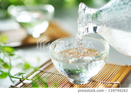 夏日里,將冰鎮清酒倒入清酒杯中(圖) 夏日里,將冰鎮清酒倒入清酒杯中(圖) 139748262