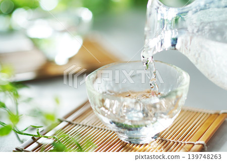 Pouring chilled sake into a sake cup in summer (image) Pouring chilled sake into a sake cup in summer (image) 139748263