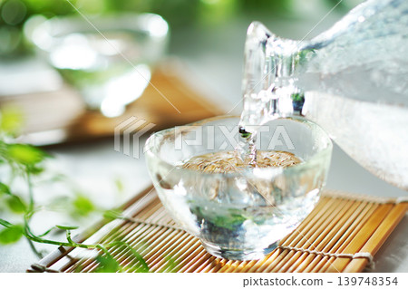 Pouring chilled sake into a sake cup in summer (image) Pouring chilled sake into a sake cup in summer (image) 139748354