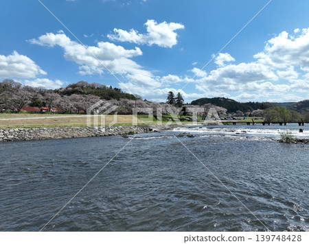 Aerial footage of the Hii River, the Wish Bridge and cherry blossom trees, a submersible bridge in springtime. Aerial footage of the Hii River, the Wish Bridge and cherry blossom trees, a submersible bridge in springtime. 139748428
