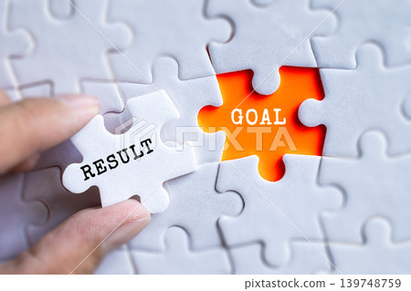 Hand fitting Result and Goal orange puzzle pieces together on gray jigsaw background, business achievement and performance management concept Hand fitting Result and Goal orange puzzle pieces together on gray jigsaw background, business achievement and performance management concept 139748759