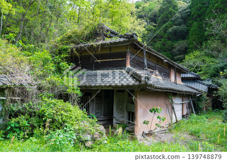 A dilapidated house that looks like it's about to be swallowed by trees A dilapidated house that looks like it's about to be swallowed by trees 139748879