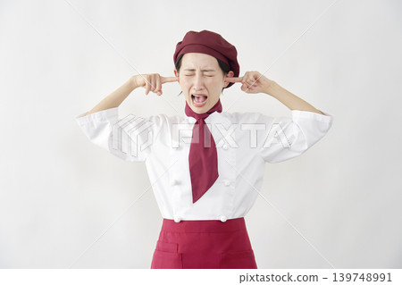 一位女糕點師/麵包師/咖啡館員工摀著耳朵，背景是白色。 139748991