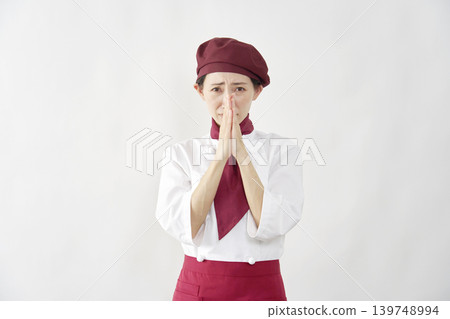 Female pastry chef/baker/cafe employee pleading against a white background. Female pastry chef/baker/cafe employee pleading against a white background. 139748994