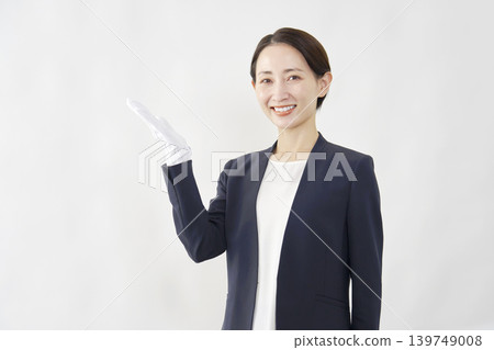 A female fortune teller points to the left with her palm against a white background. A female fortune teller points to the left with her palm against a white background. 139749008