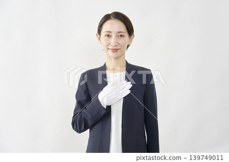 A female appraiser with her hand on her chest; portrait; white background; looking directly at the camera. A female appraiser with her hand on her chest; portrait; white background; looking directly at the camera. 139749011