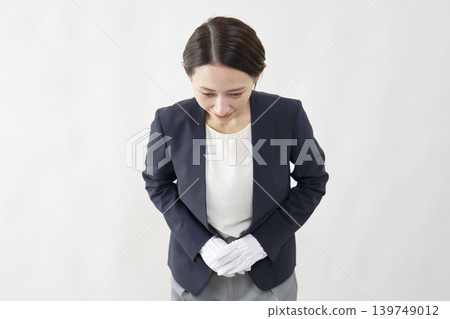 A female appraiser bows against a white background. A female appraiser bows against a white background. 139749012