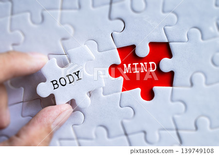 Hand fitting Body and Mind red puzzle pieces together on gray jigsaw background, mental and physical health wellness balance concept Hand fitting Body and Mind red puzzle pieces together on gray jigsaw background, mental and physical health wellness balance concept 139749108