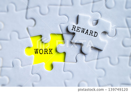 Work and Reward yellow puzzle pieces on gray jigsaw background, employee motivation and business performance management concept Work and Reward yellow puzzle pieces on gray jigsaw background, employee motivation and business performance management concept 139749120