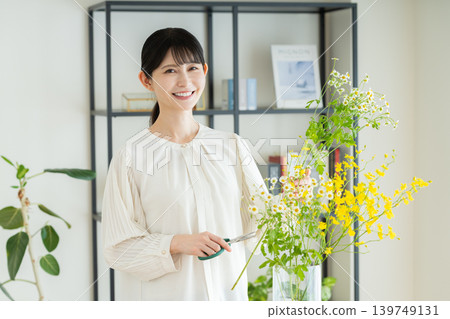 A middle-aged woman arranging flowers at home A middle-aged woman arranging flowers at home 139749131
