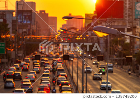 Golden hour traffic jam on a busy highway with city skyline at sunset 139749200