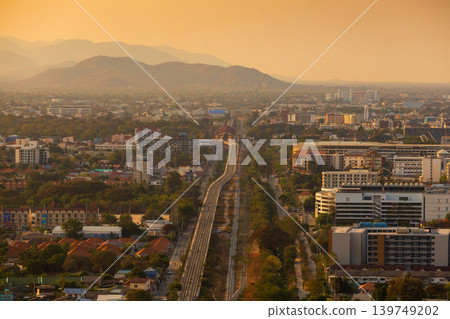 Aerial view of a sprawling city with mountains in the background during golden hour Aerial view of a sprawling city with mountains in the background during golden hour 139749202