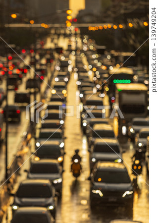 Golden hour traffic jam with bokeh lights and a lone motorcyclist 139749204