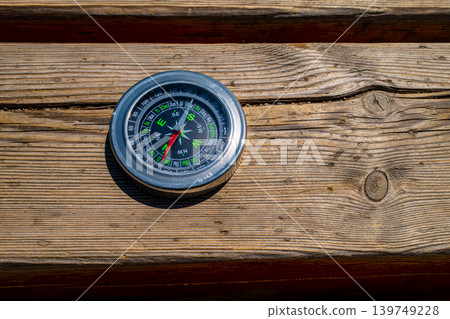 Magnetic compass on rustic weathered wooden plank table surface Magnetic compass on rustic weathered wooden plank table surface 139749228