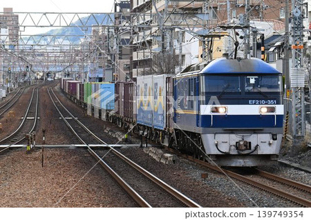 A long freight train on the quadruple Tokaido Main Line passes Konan-Yamate Station 139749354